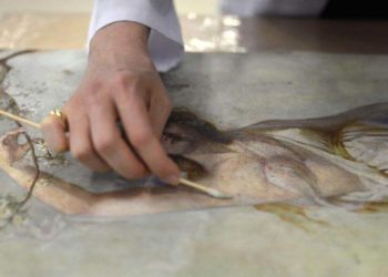 art restorer restorating a painting